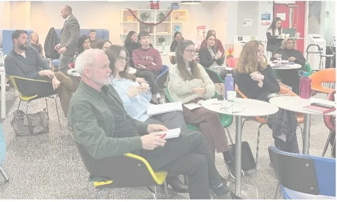 Group of people attentively listening in a meeting.